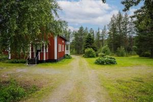 Vemhån的住宿－Nära fjäll och natur!，前面有一条土路的红色谷仓