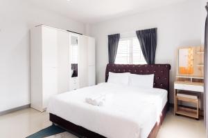 1 dormitorio con cama blanca y escritorio en AABAN House 02, en Hat Yai