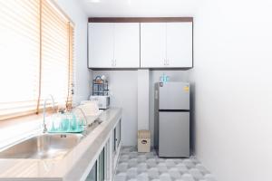 La cuisine est équipée d'un réfrigérateur et d'un évier. dans l'établissement AABAN House 02, à Hat Yai