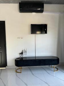 a black bench in a room with a tv on the wall at Superior Villa in Mirpur city Azad kashmir 