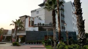 a building with palm trees in front of it at hotel badri palace in Jodhpur