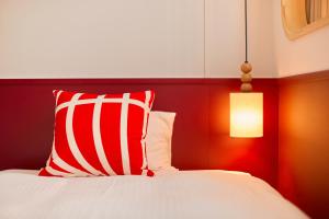 京都的住宿－京都塔酒店，一张带红白枕头和灯的床