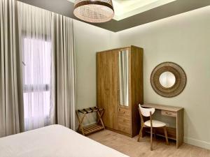 una camera con letto, scrivania e specchio di Aurora Residence - شقة أورورا a Riyad