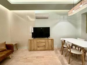 soggiorno con TV a schermo piatto e mobile in legno di Aurora Residence - شقة أورورا a Riyad