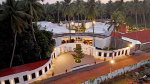 an aerial view of a white building with palm trees at The Saravi Resort in Kottakupam
