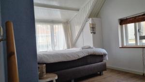 a small bedroom with a bed and a window at cottage near the beach in the center.**** in Noordwijk