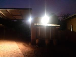 a light on the side of a building at night at A humble abode that is cozy in Centurion