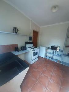 a kitchen with a stove and a tile floor at A humble abode that is cozy in Centurion