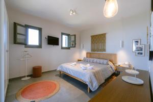 a bedroom with a bed and a table in it at Villa Rosa - Luxury Villas with Panoramic Views in Lagoúdi Zía +138 photos