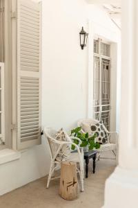 a porch with chairs and a table and a plant at The River Bend Cottages in Graaff-Reinet