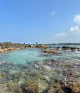 uma praia com pedras e água em Gendawana villa em Ambalangoda