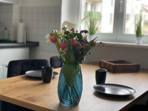 un vase rempli de fleurs assis sur une table dans l'établissement Charmante Wohnung in der Südvorstadt, à Leipzig