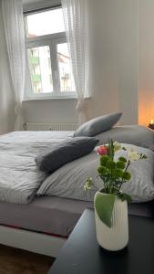 ein Schlafzimmer mit einem Bett und einer Vase mit Blumen auf dem Tisch in der Unterkunft Charmante Wohnung in der Südvorstadt in Leipzig