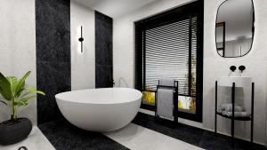 łazienka z dużą białą wanną i oknem w obiekcie Amber Blue Wellness & SPA w Karwii