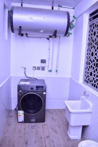ein Badezimmer mit einer Waschmaschine und einem WC in der Unterkunft El ma Furnished Apartment in Nairobi