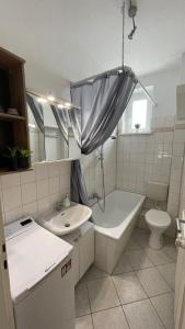 La salle de bains est pourvue d'un lavabo, d'une baignoire et de toilettes. dans l'établissement Charmante Wohnung in der Südvorstadt, à Leipzig