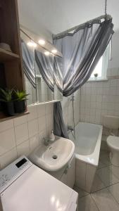 ein Badezimmer mit einem Waschbecken, einem WC und einer Badewanne in der Unterkunft Charmante Wohnung in der Südvorstadt in Leipzig
