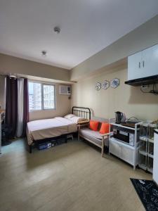 een slaapkamer met een bed en een bank erin bij New Cute&Cozy Fully Furnished Studio - Avida Towers in Iloilo City