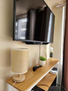 a flat screen tv sitting on a shelf with a lamp at New Cute&Cozy Fully Furnished Studio - Avida Tower 2 - 100 Mbps wifi in Iloilo City