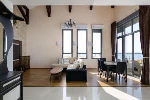ein Wohnzimmer mit einem Sofa und einem Tisch in der Unterkunft Jacuzzi Penthouse with wide Sea View in Natanya in Netanya