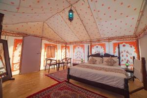 a bedroom with a bed and a table in it at Desert Camps Heritage Jaisalmer in Jaisalmer