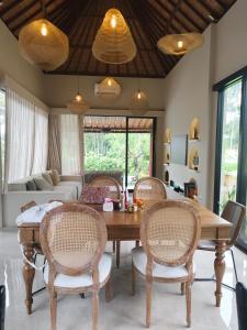 een woonkamer met een houten tafel en stoelen bij Adi Laxmi Villa Ubud in Ubud