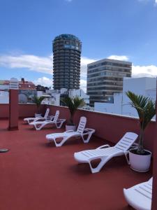 una fila de sillones blancos en un techo en Rosamar Playa de Las Canteras, en Las Palmas de Gran Canaria