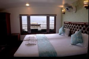 una camera da letto con un grande letto con una grande finestra di Victoria Houseboats a Alleppey