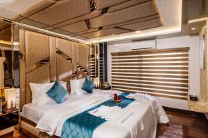 ein Schlafzimmer mit einem großen weißen Bett mit blauen Kissen in der Unterkunft Victoria Houseboats in Alappuzha