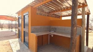 an outdoor bathroom with a sink in a building at Opuwo Country Lodge Campsite in Opuwo
