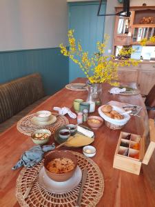 una mesa con muchos platos de comida. en B&B De NieuwenHof 'De Tuinkamer', en Melderslo