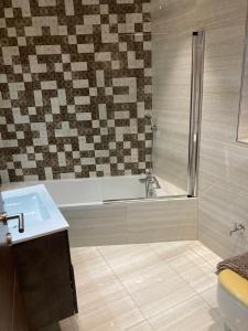 y baño con ducha, bañera y lavamanos. en Side SeaView 3Bedrooms Apartment Sliema steps from Promenade and Sliema Ferry, en Sliema