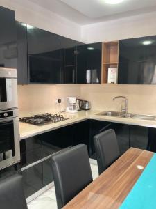 a kitchen with black cabinets and a sink and a table at Side SeaView 3Bedrooms Apartment Sliema steps from Promenade and Sliema Ferry in Sliema