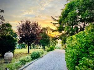 un camino de grava en un parque con árboles y una puesta de sol en Agriturismo CasaViVa, en Pozzo