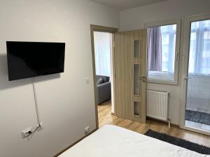 a bedroom with a bed with a flat screen tv on the wall at Casa Darius 2 in Alexandria