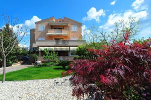 een gebouw met een bos planten ervoor bij APARTMANI VILLA ELVIRA in Sukošan