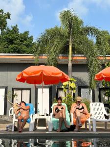 a group of people sitting in lawn chairs next to a pool at Samui Backpacker Hotel in Bangrak Beach