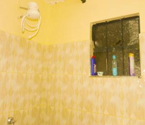 La salle de bains est pourvue d'un miroir, d'un lavabo et d'une fenêtre. dans l'établissement Jack Haven Bnb, à Kitengela 