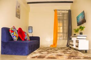 a living room with a purple couch and a window at Jack Haven Bnb in Kitengela 
