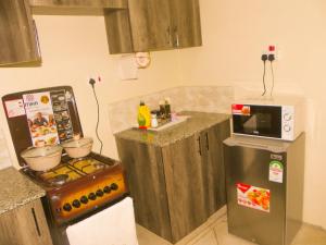 a kitchen with a refrigerator and a sink in it at Jack Haven Bnb in Kitengela 
