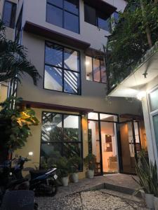 a house with windows and a scooter parked in front at WILDROSE INN in El Nido