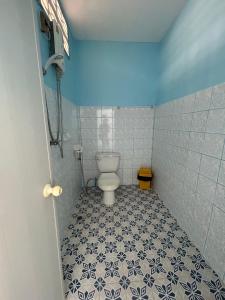 La salle de bains est pourvue de toilettes et de carrelage bleu et blanc. dans l'établissement Adam Bungalows, à Krabi