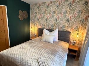 a bedroom with a bed with a floral wallpaper at Brauner Bär mit Donaublick in Altenberg