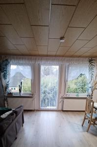 a living room with two windows and a couch at Sonja gemütliche Ferienwohnung in Bruchhausen-Vilsen