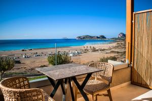 a table and chairs on a balcony with a view of a beach at Panorama Hotel in Falasarna