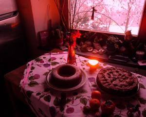 a table with a cake and a candle and a window at Agriturismo Bellavista in Monte San Martino