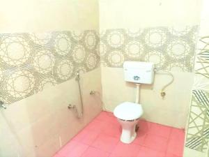 a bathroom with a white toilet in a room at Kumkum paying guest house in Ayodhya