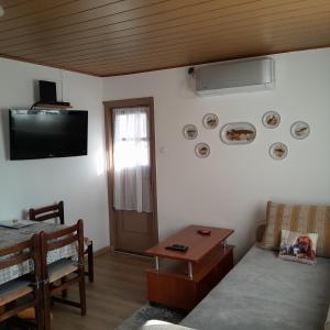 a living room with a couch and a tv on the wall at Apartman 1 RIBIČ in Ogulin