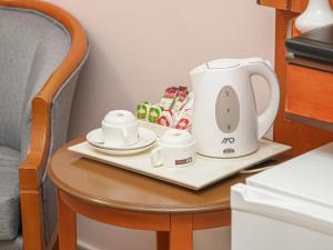 a tea kettle and cups on a tray on a table at Diyar Al Deafah Hotel in Mecca