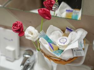 a basket of towels and flowers on a bathroom sink at Diyar Al Deafah Hotel in Mecca